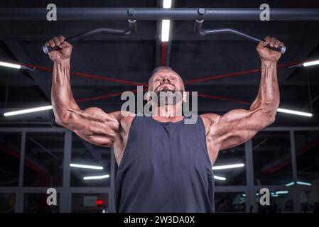 Bild eines leistungsstarken Athleten, der im Fitnessstudio einen Pull-Up macht. Rückpumpen. Fitness- und Bodybuilding-Konzept Stockfoto