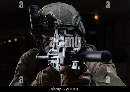 Der Soldat der Spezialeinheit zielt auf den Kollimatorblick seines Maschinengewehrs. Gemischte Medien Stockfoto