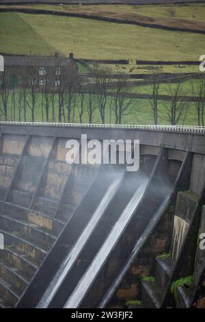 West Yorkshire, Großbritannien. Dezember 2023. Wetter in Großbritannien. Als Sturm Pia starke Winde und starke Regenfälle durch Großbritannien bringt, weht das Wasser aus dem Überfluss des Baitings Dam, Ripponden, West Yorkshire nach oben, als Böen über 60 km/h in den Pennines treffen. Das Baitings Reservoir ist ein großes Wasserreservoir, das von Yorkshire Water in der Nähe von Ripponden in den West Yorkshire Pennines betrieben wird. Er liegt im Tal des Ryburn River und ist der höhere von zwei Stauseen, die zur Versorgung Wakefield mit Wasser gebaut wurden und 1956 fertiggestellt wurden. Quelle: Windmill Images/Alamy Live News Stockfoto