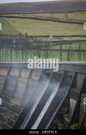 West Yorkshire, Großbritannien. Dezember 2023. Wetter in Großbritannien. Als Sturm Pia starke Winde und starke Regenfälle durch Großbritannien bringt, weht das Wasser aus dem Überfluss des Baitings Dam, Ripponden, West Yorkshire nach oben, als Böen über 60 km/h in den Pennines treffen. Das Baitings Reservoir ist ein großes Wasserreservoir, das von Yorkshire Water in der Nähe von Ripponden in den West Yorkshire Pennines betrieben wird. Er liegt im Tal des Ryburn River und ist der höhere von zwei Stauseen, die zur Versorgung Wakefield mit Wasser gebaut wurden und 1956 fertiggestellt wurden. Quelle: Windmill Images/Alamy Live News Stockfoto