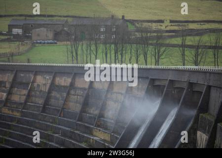 West Yorkshire, Großbritannien. Dezember 2023. Wetter in Großbritannien. Als Sturm Pia starke Winde und starke Regenfälle durch Großbritannien bringt, weht das Wasser aus dem Überfluss des Baitings Dam, Ripponden, West Yorkshire nach oben, als Böen über 60 km/h in den Pennines treffen. Das Baitings Reservoir ist ein großes Wasserreservoir, das von Yorkshire Water in der Nähe von Ripponden in den West Yorkshire Pennines betrieben wird. Er liegt im Tal des Ryburn River und ist der höhere von zwei Stauseen, die zur Versorgung Wakefield mit Wasser gebaut wurden und 1956 fertiggestellt wurden. Quelle: Windmill Images/Alamy Live News Stockfoto