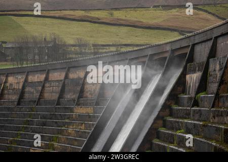 West Yorkshire, Großbritannien. Dezember 2023. Wetter in Großbritannien. Als Sturm Pia starke Winde und starke Regenfälle durch Großbritannien bringt, weht das Wasser aus dem Überfluss des Baitings Dam, Ripponden, West Yorkshire nach oben, als Böen über 60 km/h in den Pennines treffen. Das Baitings Reservoir ist ein großes Wasserreservoir, das von Yorkshire Water in der Nähe von Ripponden in den West Yorkshire Pennines betrieben wird. Er liegt im Tal des Ryburn River und ist der höhere von zwei Stauseen, die zur Versorgung Wakefield mit Wasser gebaut wurden und 1956 fertiggestellt wurden. Quelle: Windmill Images/Alamy Live News Stockfoto