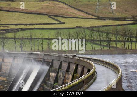 West Yorkshire, Großbritannien. Dezember 2023. Wetter in Großbritannien. Als Sturm Pia starke Winde und starke Regenfälle durch Großbritannien bringt, weht das Wasser aus dem Überfluss des Baitings Dam, Ripponden, West Yorkshire nach oben, als Böen über 60 km/h in den Pennines treffen. Das Baitings Reservoir ist ein großes Wasserreservoir, das von Yorkshire Water in der Nähe von Ripponden in den West Yorkshire Pennines betrieben wird. Er liegt im Tal des Ryburn River und ist der höhere von zwei Stauseen, die zur Versorgung Wakefield mit Wasser gebaut wurden und 1956 fertiggestellt wurden. Quelle: Windmill Images/Alamy Live News Stockfoto