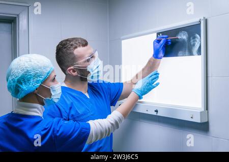 Zwei Ärzte untersuchen ein Röntgenbild. Radiologie. Medizinisches Konzept. Gemischte Medien Stockfoto
