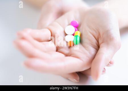 Bild der Pillen auf einer weiblichen Handfläche. Das Konzept von Medizin, Gesundheit, Vitaminen. Gemischte Medien Stockfoto