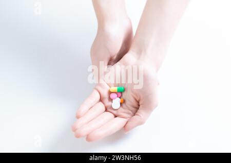 Bild der Pillen auf einer weiblichen Handfläche. Das Konzept von Medizin, Gesundheit, Vitaminen. Gemischte Medien Stockfoto