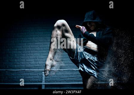 Thai Boxer im Ring schlägt mit einem Knie. Das Konzept von Sport, Turnhallen, Boxclubs. Gemischte Medien Stockfoto