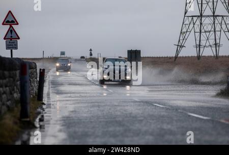 West Yorkshire, Großbritannien. Dezember 2023. Wetter in Großbritannien. Fahrer und Verkehrsteilnehmer sind mit schwierigen Fahrbedingungen konfrontiert, da starke Winde Wasser aus dem Blackstone Edge Reservoir über die Turin Road und die Grenze von Rochdale und Calderdale treiben, während Storm Pia den hohen Pennine-Boden zwischen Leeds und Manchester durchquert. Quelle: Windmill Images/Alamy Live News Stockfoto