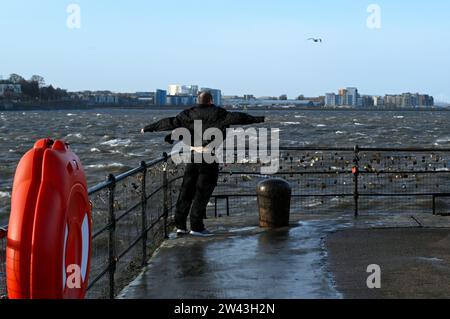 Edinburgh, Schottland, Großbritannien. Dezember 2023. Sturm Pia bringt starke Winde und stürmisches Wetter in den Hafen von Newhaven an der vierten Mündung. Besucher, die sich gegen den Wind mit Blick auf das turbulente Wasser auf die moderne Entwicklung in Granton stützen. Quelle: Craig Brown/Alamy Live News Stockfoto