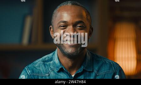 Kopfaufnahme Nahaufnahme lächelnd zuversichtlich glücklicher afroamerikaner, der die Kamera zu Hause sieht zufriedener reifer Kerl Geschäftsmann Kunde Model posiert Stockfoto