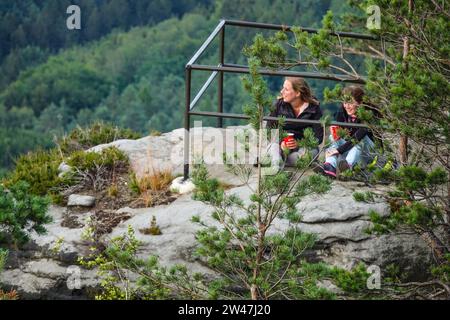 Zwei Mädchen sitzen auf einer Spitze des Elbsandsteingebirges und blicken auf die Landschaft, Sachsen Deutschland Europa Stockfoto