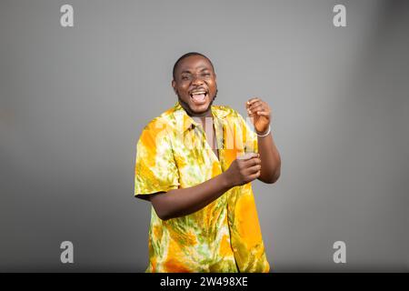 Überregter junger Schwarzer, der die Faust auf weißem Hintergrund hochhebt und den Erfolg feiert. Glücklicher afrikanischer Millennial-Mann, der positive Emotionen teilt, Copy Spa Stockfoto