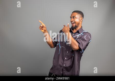Überregter junger Schwarzer, der die Faust auf weißem Hintergrund hochhebt und den Erfolg feiert. Glücklicher afrikanischer Millennial-Mann, der positive Emotionen teilt, Copy Spa Stockfoto