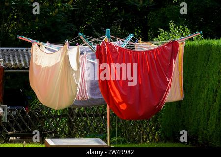 Airer-Wäscheleine, bunt, Wäsche auf rotierender Wäscheleine, saubere Wäsche waschen, Wäscheleine trocknen im Garten Stockfoto