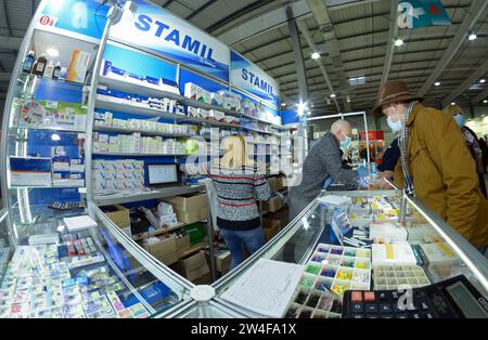 Verkäufer berät Kunden, die vor der Theke des Fachs für medizinische Instrumente stehen. EXPODENTAL Ausstellung. 25. November 2020. Kiew, Ukraine Stockfoto