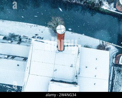 Roter Kamin auf einem schneebedeckten Dach eines Gebäudes, aus der Luft fotografiert, Schwarzwald, Calw, Deutschland Stockfoto