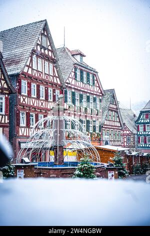 Fachwerkhauskulisse auf einem schneebedeckten Weihnachtsmarkt mit Winterdekoration, Schwarzwald, Calw, Deutschland Stockfoto