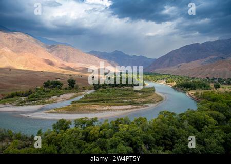 Grünes Flusstal mit dem Fluss Naryn zwischen Bergen, Berglandschaft in der Nähe von Kasarman, Region Naryn, Kirgisistan Stockfoto