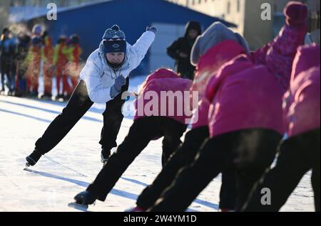 (231221) -- URUMQI, 21. Dezember 2023 (Xinhua) -- Ein Lehrer führt die Schüler dazu, an der Shuixigou Mittelschule im Bezirk Urumqi, nordwestchinesische Autonome Region Xinjiang Uygur, 20. Dezember 2023 teilzunehmen. Die Shuixigou Middle School, eine neunjährige Bildungsschule im Bezirk Urumqi in Xinjiang, entwickelt ihre Wintersportausbildung seit mehr als 20 Jahren. Die Schüler erhalten elementare Eislaufkurse in den unteren Klassen, danach können sie je nach individuellen Umständen im Eislaufteam, Eishockeyteam oder Eiskunstlauf-Team teilnehmen. Jahre o Stockfoto