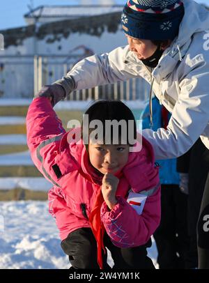 (231221) -- URUMQI, 21. Dezember 2023 (Xinhua) -- Ein Lehrer führt einen Schüler dazu, an der Shuixigou Mittelschule im Bezirk Urumqi, nordwestchinesische Autonome Region Xinjiang Uygur, 20. Dezember 2023 teilzunehmen. Die Shuixigou Middle School, eine neunjährige Bildungsschule im Bezirk Urumqi in Xinjiang, entwickelt ihre Wintersportausbildung seit mehr als 20 Jahren. Die Schüler erhalten elementare Eislaufkurse in den unteren Klassen, danach können sie je nach individuellen Umständen im Eislaufteam, Eishockeyteam oder Eiskunstlauf-Team teilnehmen. Jahre Stockfoto