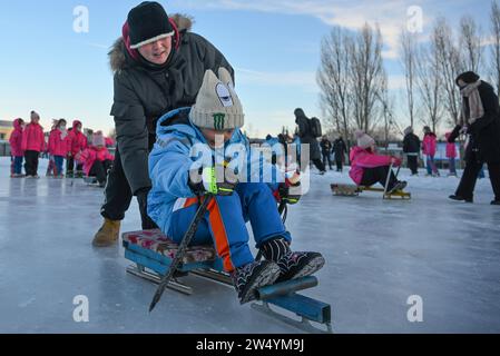 (231221) -- URUMQI, 21. Dezember 2023 (Xinhua) -- Schüler erleben Eisschlitten unter der Leitung von Lehrern an der Shuixigou-Mittelschule im Bezirk Urumqi, nordwestchinesische Autonome Region Xinjiang Uygur, 20. Dezember 2023. Die Shuixigou Middle School, eine neunjährige Bildungsschule im Bezirk Urumqi in Xinjiang, entwickelt ihre Wintersportausbildung seit mehr als 20 Jahren. Die Schüler erhalten elementare Eislaufkurse in den unteren Klassen, danach können sie je nach individuellen Umständen im Eislaufteam, Eishockeyteam oder Eiskunstlauf-Team teilnehmen. Y Stockfoto