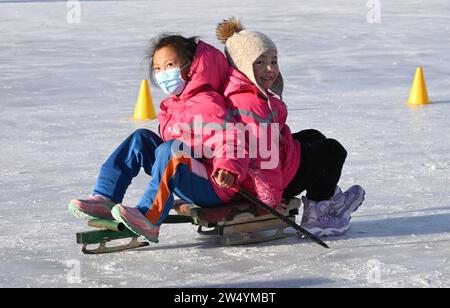 (231221) -- URUMQI, 21. Dezember 2023 (Xinhua) -- Schüler erleben einen Eisschlitten an der Shuixigou-Mittelschule in Urumqi County, nordwestchinesische Autonome Region Xinjiang Uygur, 20. Dezember 2023. Die Shuixigou Middle School, eine neunjährige Bildungsschule im Bezirk Urumqi in Xinjiang, entwickelt ihre Wintersportausbildung seit mehr als 20 Jahren. Die Schüler erhalten elementare Eislaufkurse in den unteren Klassen, danach können sie je nach individuellen Umständen im Eislaufteam, Eishockeyteam oder Eiskunstlauf-Team teilnehmen. Jahre Ausbildung zum Winter-spo Stockfoto