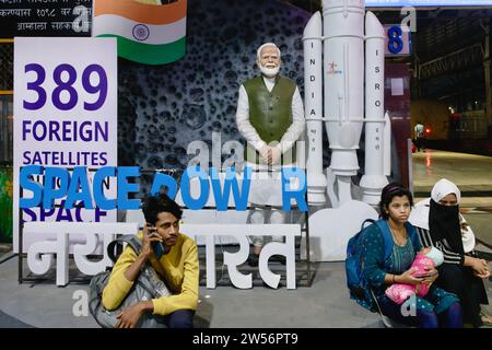 Eine Statue des indischen Premierministers Narendra Modi am Chhatrapati Shivaji Maharaj Terminus in Mumbai, Indien, mit Bahnpassagieren im Vordergrund Stockfoto