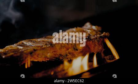 Auf dem Grill gekochtes Rindfleisch. Hofeingeweide mit Feuerflammen Stockfoto