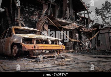 Irpin, Region Kiew, 2022. Zerstörtes Haus und Auto. Die Folgen des Beschussschlags im Krieg Russlands gegen die Ukraine. Militärkriminalität. Stockfoto