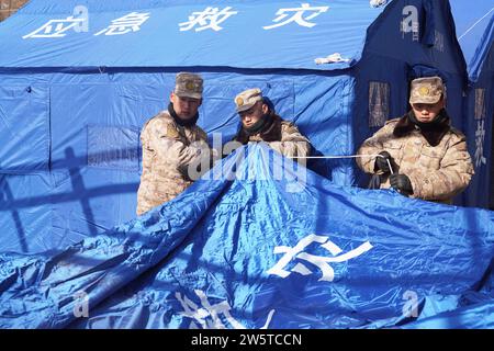 Linxia, Chinas Provinz Gansu. Dezember 2023. Soldaten errichteten Zelte für die von Erdbeben betroffenen Menschen in der Gemeinde Shiyuan, Jishishan County, nordwestchinesische Provinz Gansu, 21. Dezember 2023. Die chinesische Volksbefreiungsarmee (PLA) und die Volksarmee (PAPF) haben mehrere Rettungskräfte in Gebieten eingesetzt, die von Erdbeben betroffen sind, als Reaktion auf ein Erdbeben der Stärke 6,2, das die nordwestchinesische Provinz Gansu am späten Montag erschütterte. Quelle: Zhang Yongjin/Xinhua/Alamy Live News Stockfoto