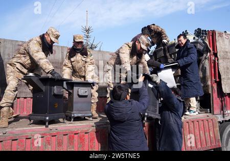 Linxia, Chinas Provinz Gansu. Dezember 2023. Soldaten entladen Öfen für Beben betroffene Menschen in Shiyuan Township, Jishishan County, nordwestchinesische Provinz Gansu, 21. Dezember 2023. Die chinesische Volksbefreiungsarmee (PLA) und die Volksarmee (PAPF) haben mehrere Rettungskräfte in Gebieten eingesetzt, die von Erdbeben betroffen sind, als Reaktion auf ein Erdbeben der Stärke 6,2, das die nordwestchinesische Provinz Gansu am späten Montag erschütterte. Quelle: Zhang Yongjin/Xinhua/Alamy Live News Stockfoto