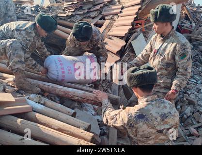 Linxia, Chinas Provinz Gansu. Dezember 2023. Soldaten helfen bei der Reinigung von Materialien für von Erdbeben betroffene Menschen in Shiyuan Township, Jishishan County, nordwestchinesische Provinz Gansu, 21. Dezember 2023. Die chinesische Volksbefreiungsarmee (PLA) und die Volksarmee (PAPF) haben mehrere Rettungskräfte in Gebieten eingesetzt, die von Erdbeben betroffen sind, als Reaktion auf ein Erdbeben der Stärke 6,2, das die nordwestchinesische Provinz Gansu am späten Montag erschütterte. Quelle: Bai Jiacheng/Xinhua/Alamy Live News Stockfoto