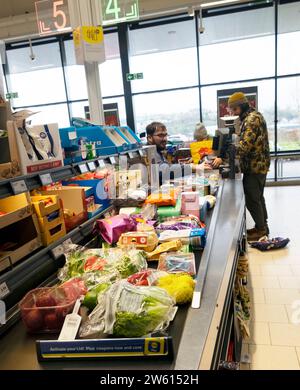 Kunde, der an der Kasse für Essen bezahlt, und Mitarbeiter, der an der Kasse im Lidl-Supermarkt in Großbritannien arbeitet, KATHY DEWITT Stockfoto