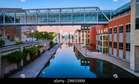 Aerial Twilight Urban mit moderner Fußgängerbrücke und Kanalreflexen Stockfoto