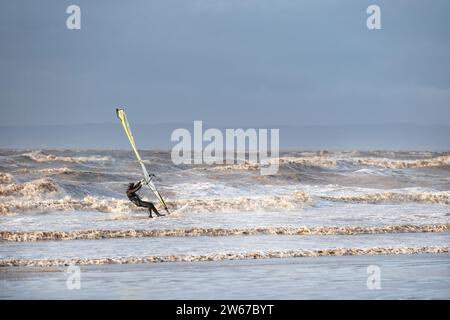 UK Weston Superstute: Ein Windsurfer kämpft gegen starke Winde und große Wellen, während er mit Geschwindigkeit über das Wasser in der Nähe der Küste reist Stockfoto