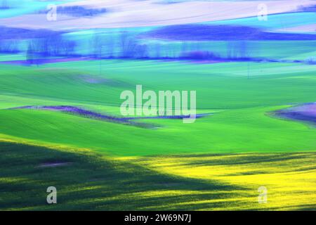 Pulsierende abstrakte Landschaft mit fließenden grünen und blauen Formen, die an die üppige Vitalität der Frühlingsfelder in Bewegung erinnern Stockfoto