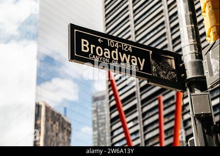 Niedriger Straßenwinkel mit modernen Gebäuden und Straßenschild Broadway Canyon of Heroes am Pol of Manhattan, New York bei hellem Tageslicht gegen Unschärfe Stockfoto