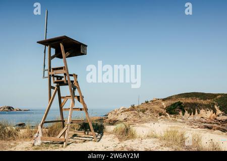 Hölzerner Aussichtsturm an der felsigen Küste am Meer vor klarem blauem Himmel auf der Insel Cies in Galicien Stockfoto