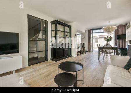 Geräumiges offenes Haus mit Holzschrank in der Nähe des Esszimmers und Wohnzimmermöbel mit Glastür Stockfoto