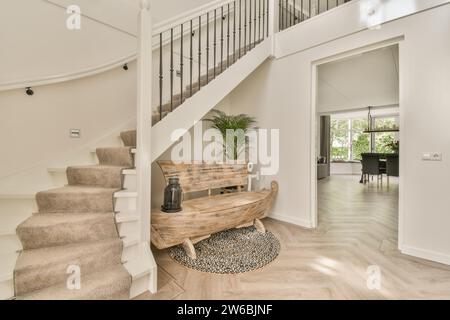 Eingangskorridor mit Treppe über hölzerne Bootsbank mit Laterne durch weiße Tür Stockfoto