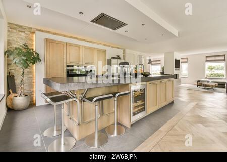 Gerät von Obstschale auf der Insel mit Hochstühlen in geräumiger Küche im offenen Bungalow Stockfoto