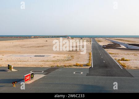 Eine Start- und Landebahn und die Küste am Hamad International Airport in Doha, Katar Stockfoto