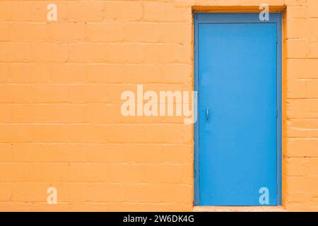 Geschlossene blaue Holztür auf gelbem Hintergrund Stockfoto