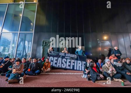 Den Haag, Niederlande. Dezember 2023. Regierungsbeamte nehmen an einem stillen Sit-in-Protest vor dem Außenministerium in den Haag Teil, um ihre Unzufriedenheit mit der abgehenden Haltung des Kabinetts gegenüber der israelischen Invasion in Gaza bekannt zu machen. Regierungsangestellte in den Haag hielten an diesem 76. Tag des israelischen Krieges und der Invasion in Gaza am Eingang des Außenministeriums eine pro-palästinensische stille Mittagssitzung ab. Quelle: SOPA Images Limited/Alamy Live News Stockfoto