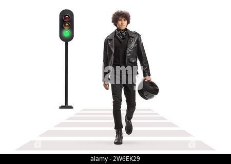 Porträt eines jungen Mannes, der einen Helm trägt und eine Straße überquert, an einer grünen Ampel isoliert auf weißem Hintergrund Stockfoto