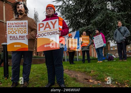 Leicester, Leicestershire, Großbritannien. Dezember 2023. Juniorärzte in Leicester gingen heute Morgen in einem Streit um die Lohnwiederherstellung an die Streitlinie im Leicester Royal Infirmary Hospital. Die Ärzte befinden sich mitten in drei Tagen Streiks, und für Januar sind weitere Arbeitskampfmaßnahmen geplant. Die Ärzte sagen, sie brauchen eine Erhöhung um 35 %, um das Niveau von 2008 zu erreichen, während die Regierung 3 % angeboten hat, um die bereits vereinbarten 8 % zu übersteigen. Dr.'s Nihal Mehra und Becky Acres auf der Streiklinie. Quelle: AG News/Alamy Live News Stockfoto