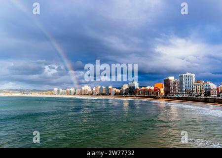 Spektakulärer Regenbogen über dem Strand San Lorenzo bei Sonnenuntergang. Gijón, Fürstentum Asturien, Spanien, Europa Stockfoto