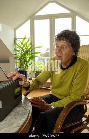 11.10.2023, Deutschland, Bremen, Bremen - pensionierter Radioredakteur hört Radio im Wohnzimmer (DAB-Radio). 00A231011D008CAROEX.JPG [MODELL RELEA Stockfoto