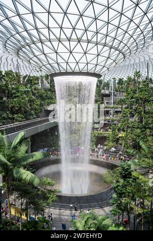 31.07.2023, Singapur, Singapur, - der Garten des Shiseido Forest Valley mit dem Indoor-Wasserfall Rain Vortex im Zentrum des modernen Jewel Termi Stockfoto
