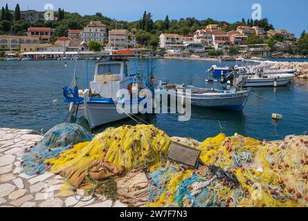 31.08.2023, Griechenland, Kassiopi, Korfu - Fischerboote und farbenfrohe Fischernetze im Hafen von Kassiopi, einer kleinen Hafenstadt im Nordosten von Th Stockfoto